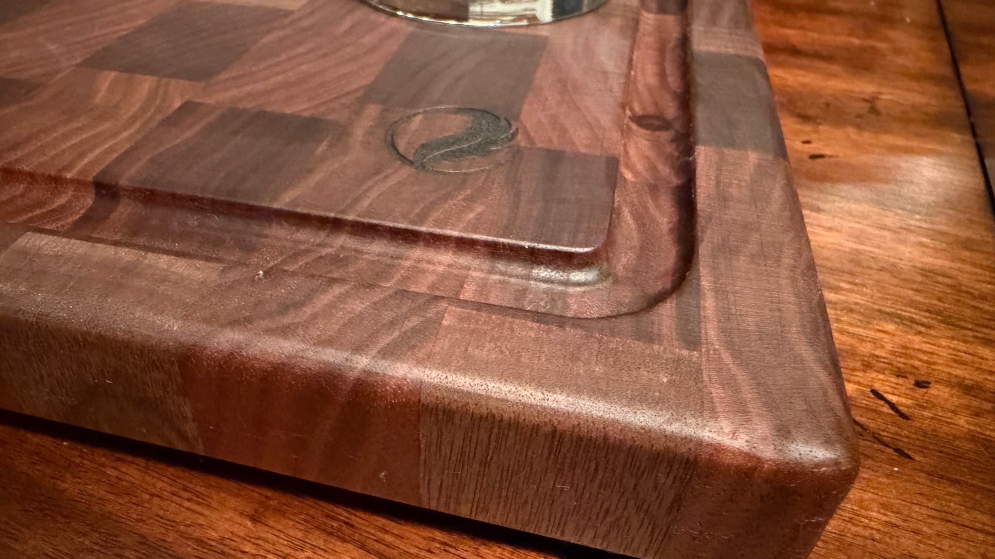 Close-up of Flight Outdoors logo inlay on end-grain walnut board corner